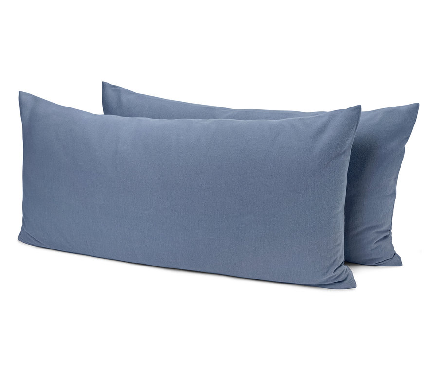 Deux oreillers bleus sont posés l'un sur l'autre.