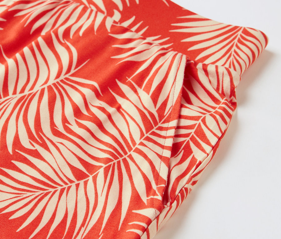 Détail d'un short en jersey imprimé avec un motif de feuilles de palmier.