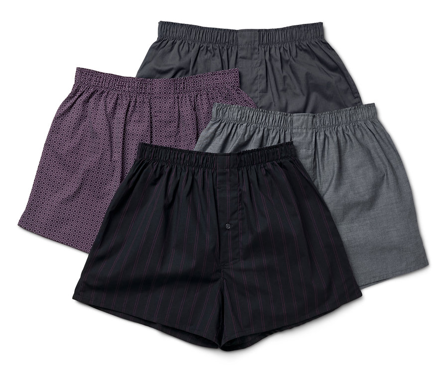 Quatre boxers pour hommes de différentes couleurs et motifs sont empilés les uns sur les autres.
