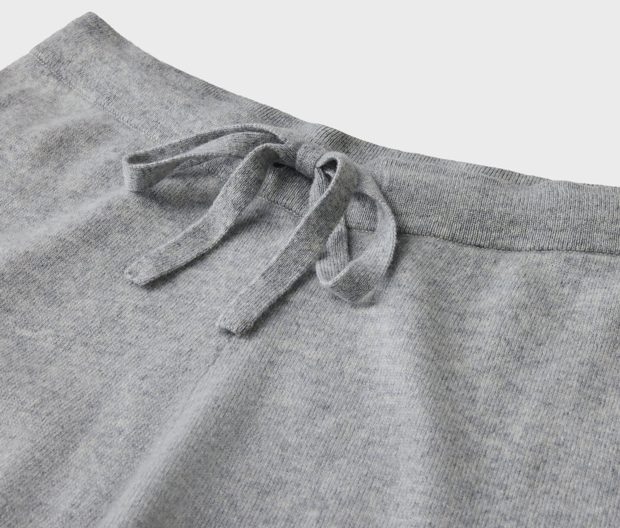 Gros plan sur un pantalon de jogging gris avec cordon de serrage.