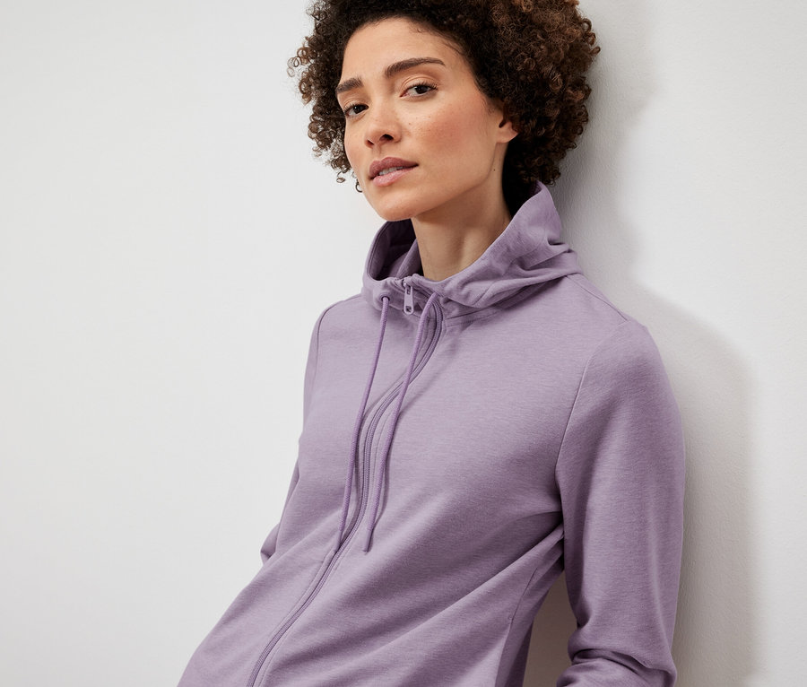 Femme posant en veste molletonnée lilas.