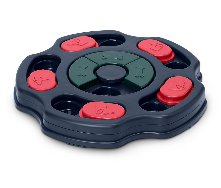 Jeu interactif pour chien avec mécanisme rotatif, couvercles rouges et os verts.