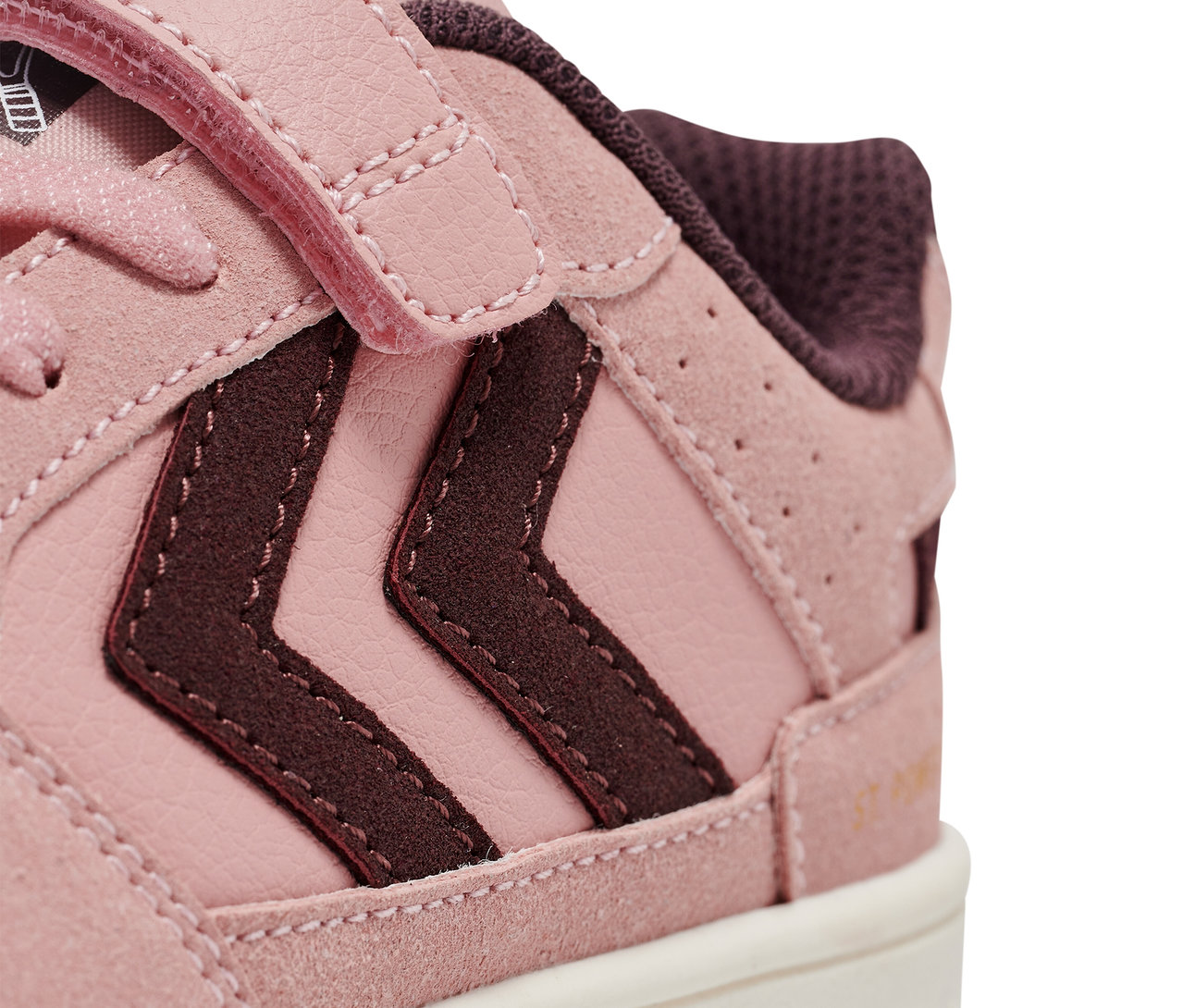Gros plan d'une chaussure rose Hummel ST Power play SP Jr.
