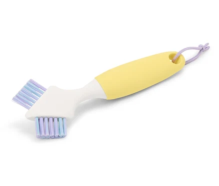Brosse de nettoyage jaune avec tête blanche et poils violets.