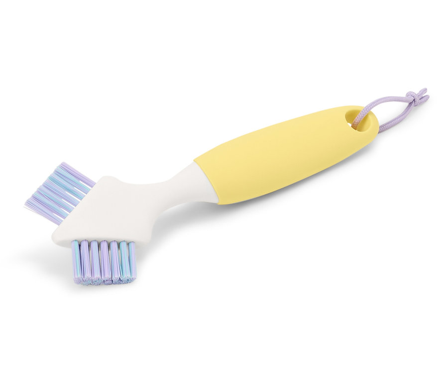 Brosse de nettoyage jaune avec tête blanche et poils violets.