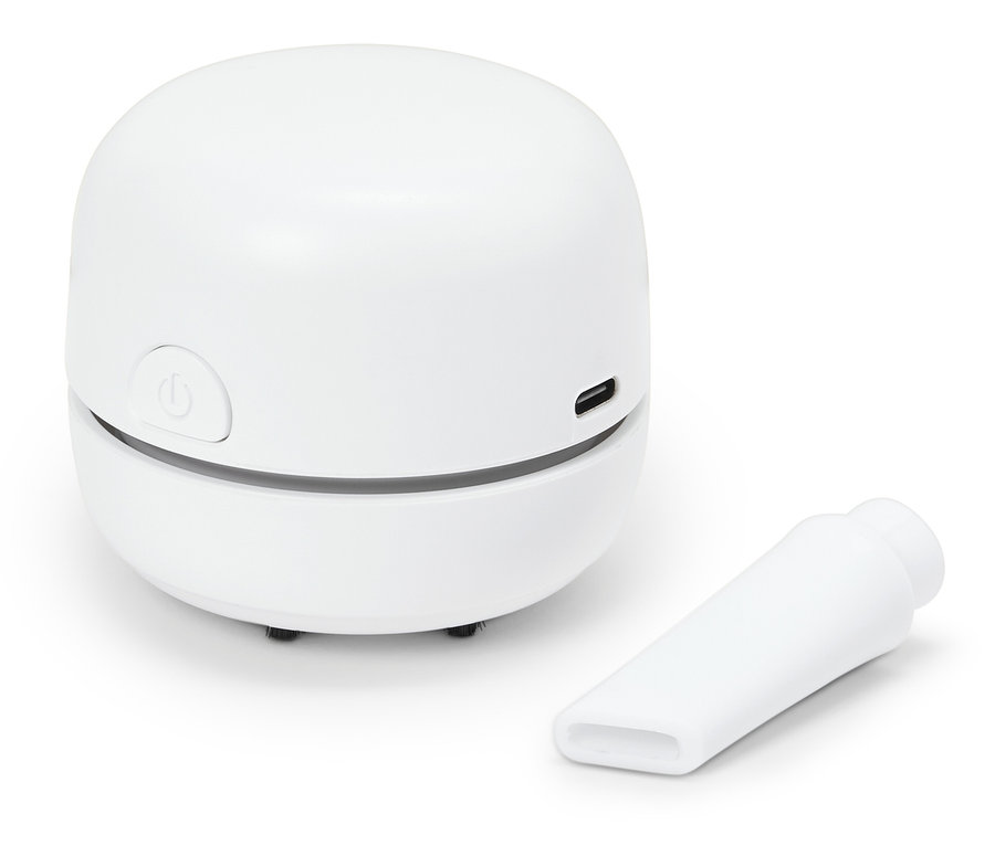 Un mini aspirateur de table blanc avec un embout sur fond blanc.