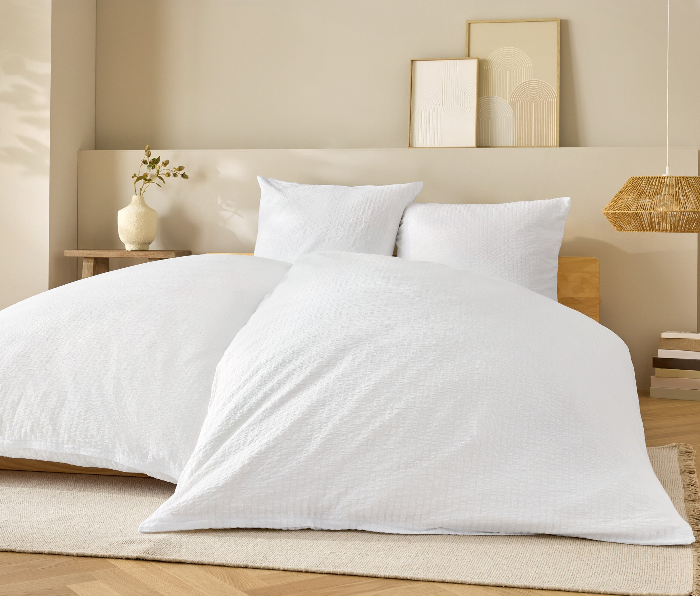 Linge de lit blanc sur un lit avec des oreillers blancs.