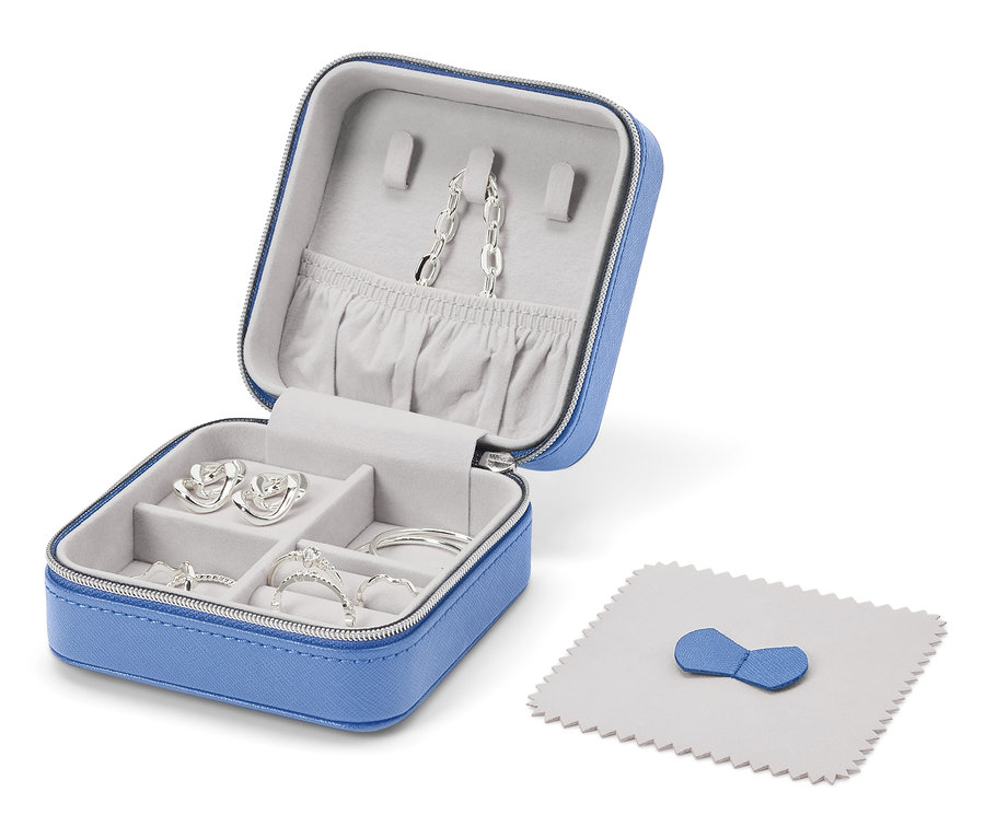Boîte à bijoux bleue ouverte avec des bijoux en argent et un chiffon de polissage.