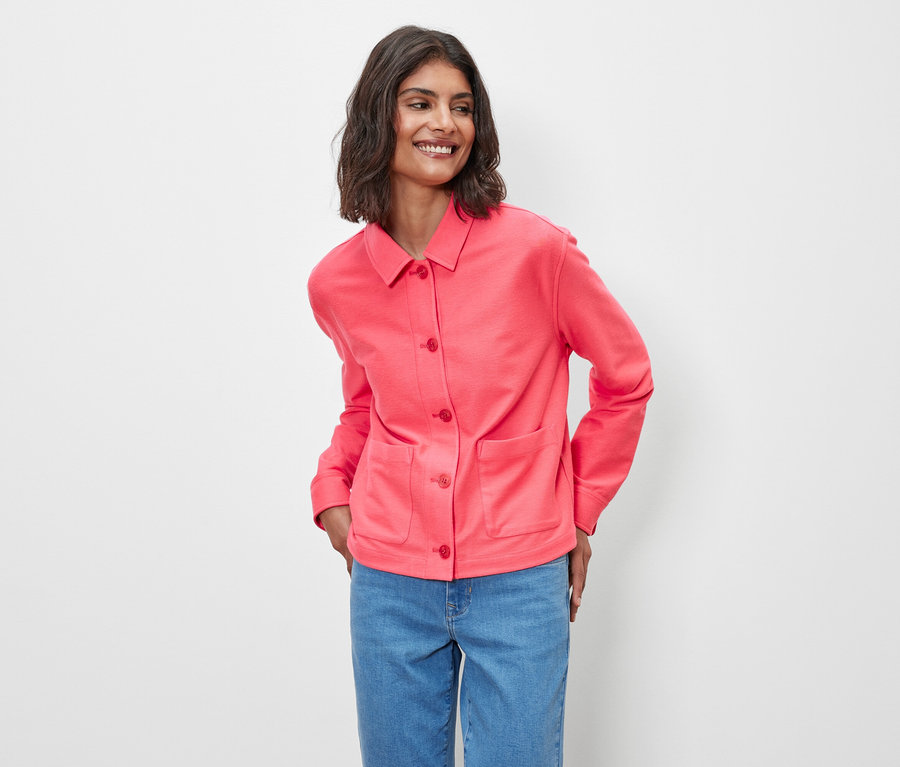 Femme posant en veste en jersey rose.