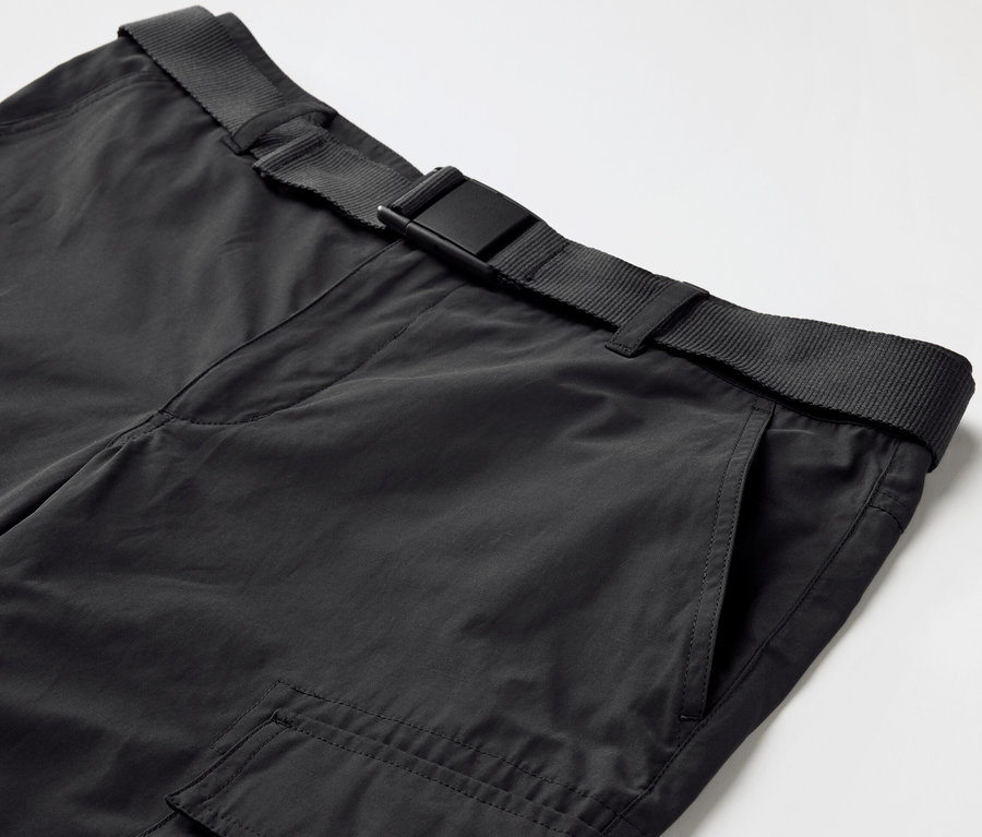 Gros plan sur un pantalon d’extérieur noir avec protection anti-moustiques et une ceinture noire.