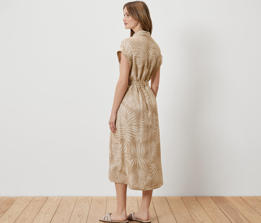 Femme debout de côté portant une robe en lin imprimée.