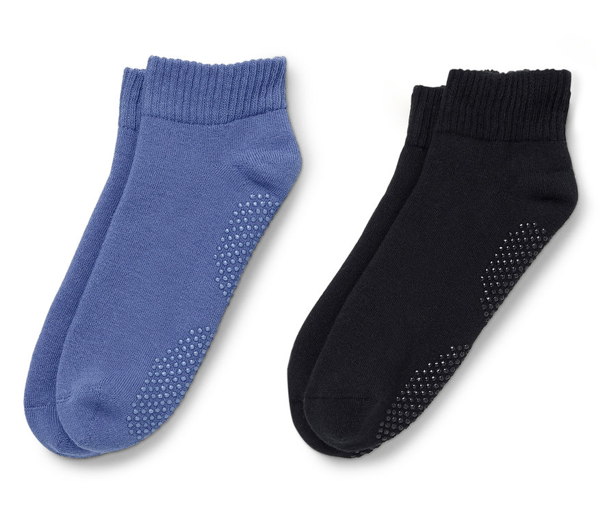 Deux paires de chaussettes, une paire bleue, une paire noire, posées sur un fond blanc.