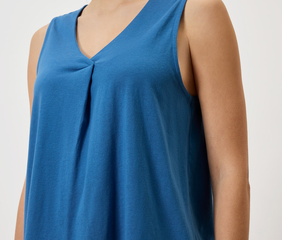 Gros plan d'une femme portant un haut bleu sans manches.