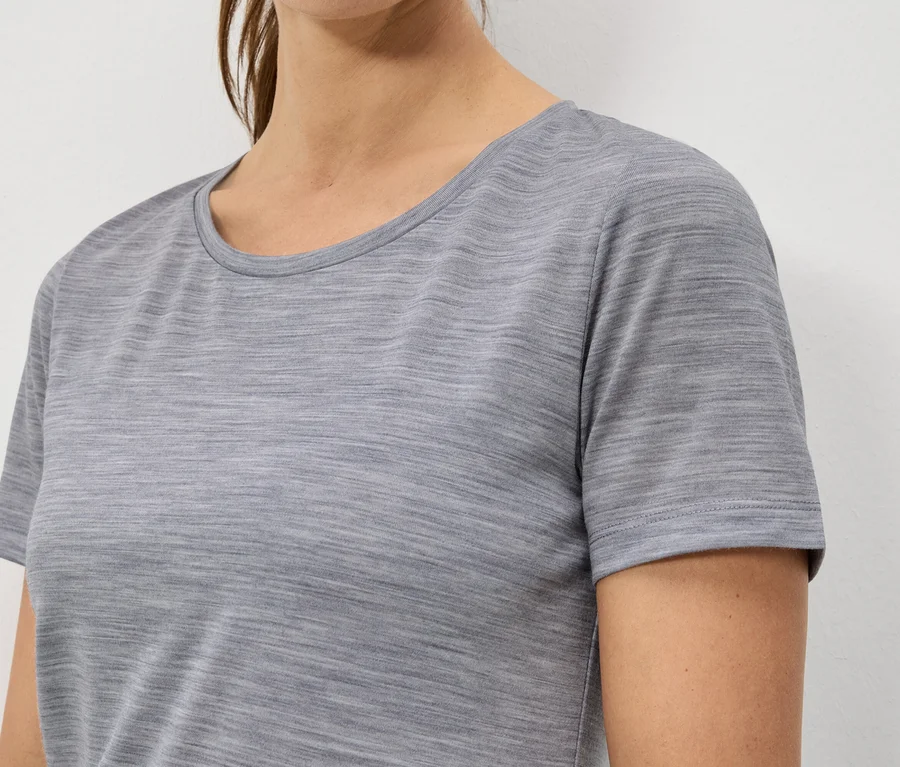 Gros plan d'une femme portant un t-shirt à manches courtes gris chiné.