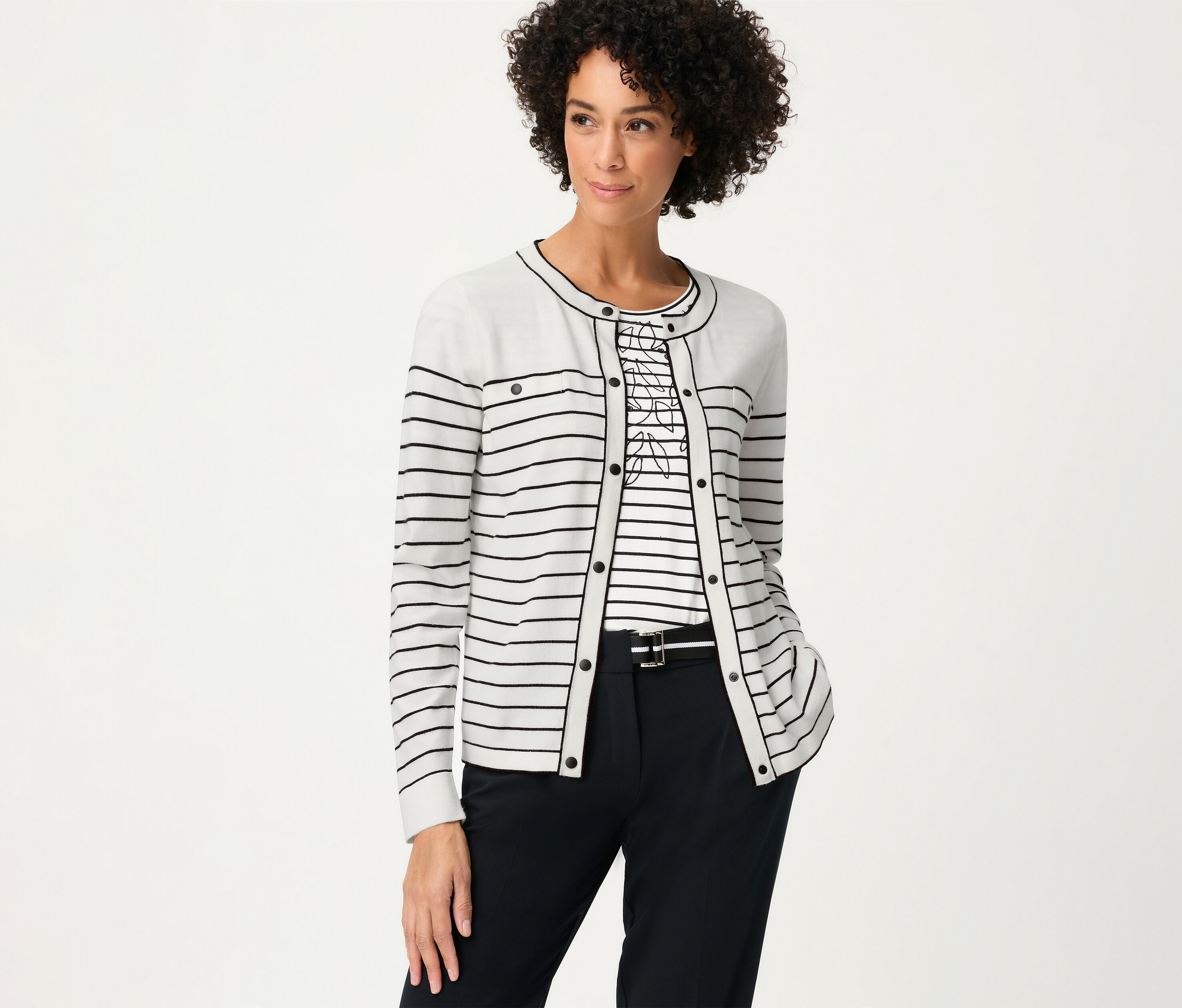 Femme portant un haut rayé et un cardigan Olsen «	LA	». Elle porte un pantalon foncé avec une ceinture.