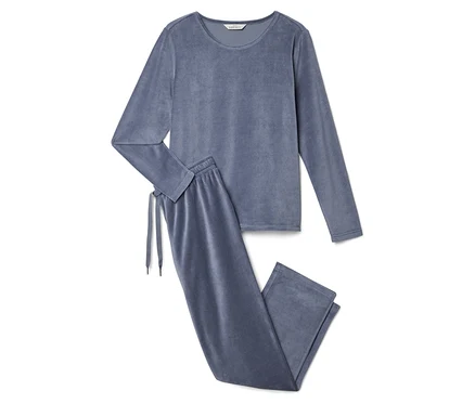 Un pyjama deux pièces en velours gris, composé d'un haut à manches longues et d'un pantalon, est posé sur un fond blanc.