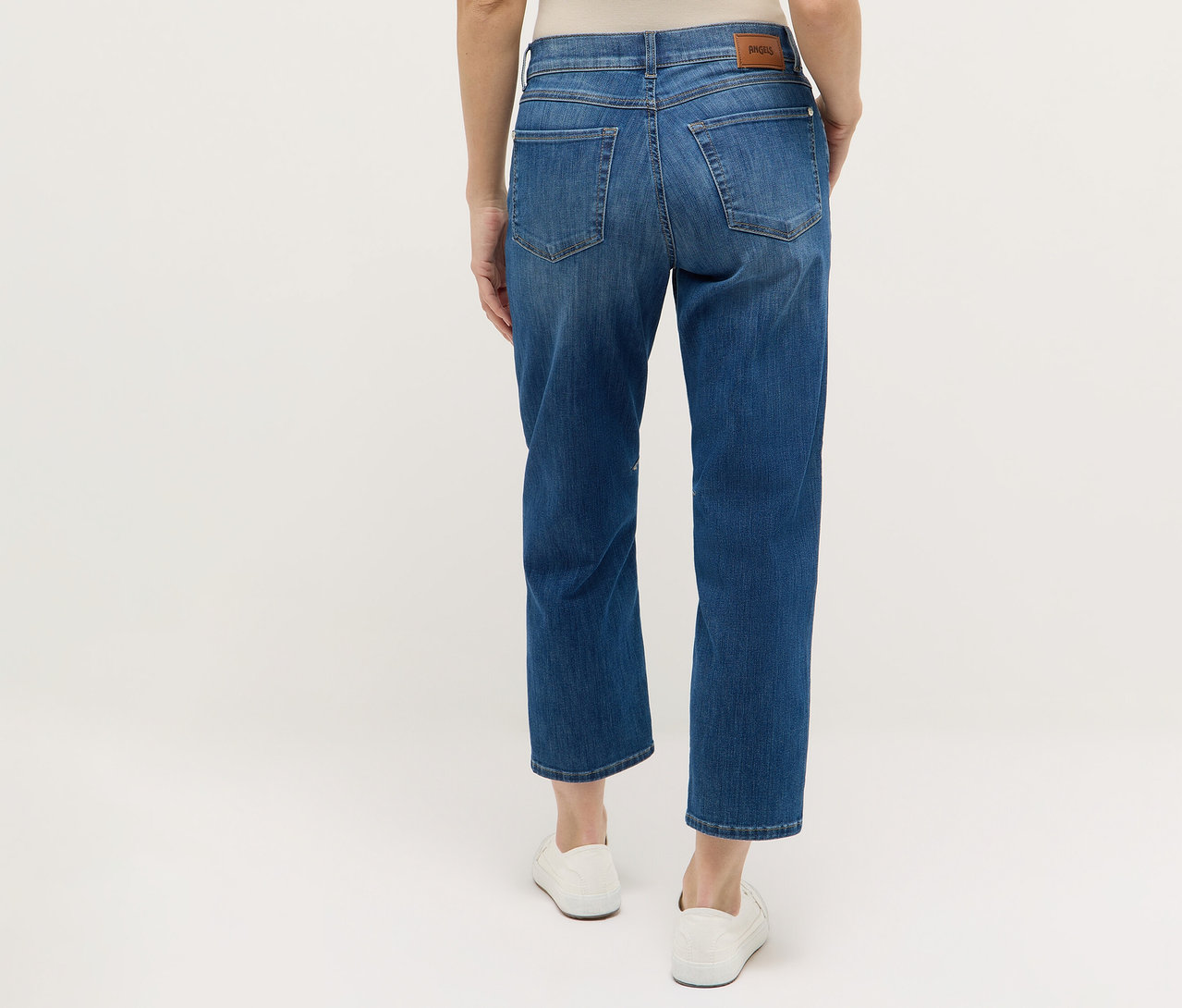 Vue arrière d'une femme portant un jean bleu Angels Denim «
Evi » et des chaussures blanches.