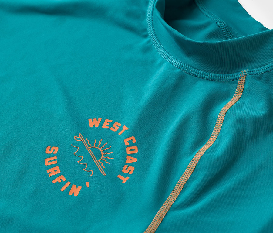 Gros plan sur un t-shirt turquoise à manches longues avec un logo orange « West Coast Surfin ».