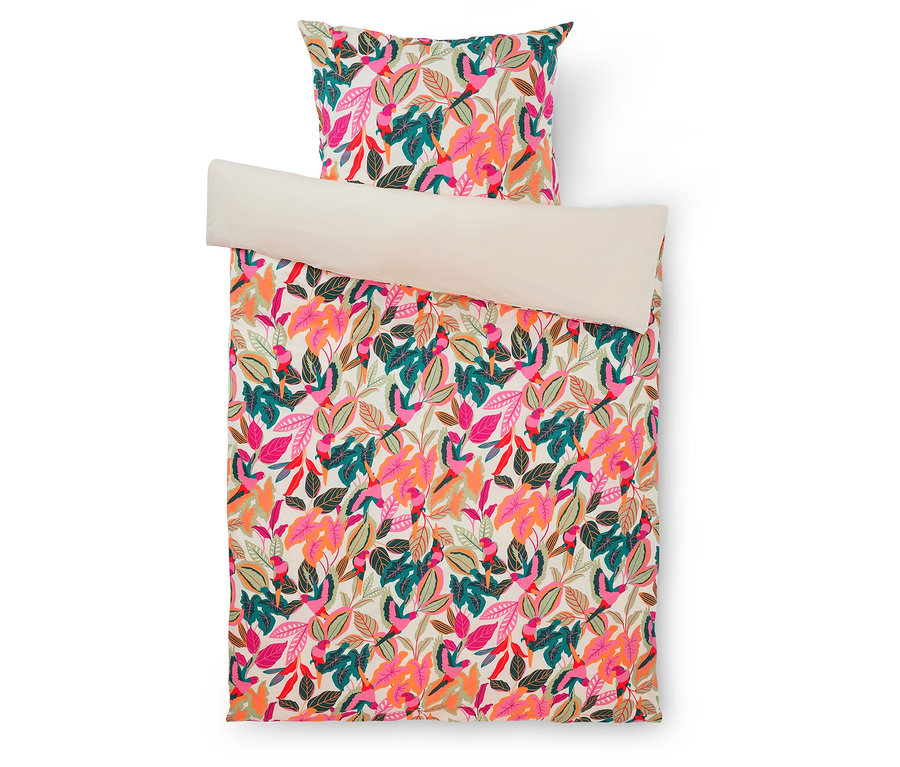 Parure de lit colorée avec un motif de feuilles roses, oranges et vertes; la couette est repliée en haut, révélant le dessous beige.