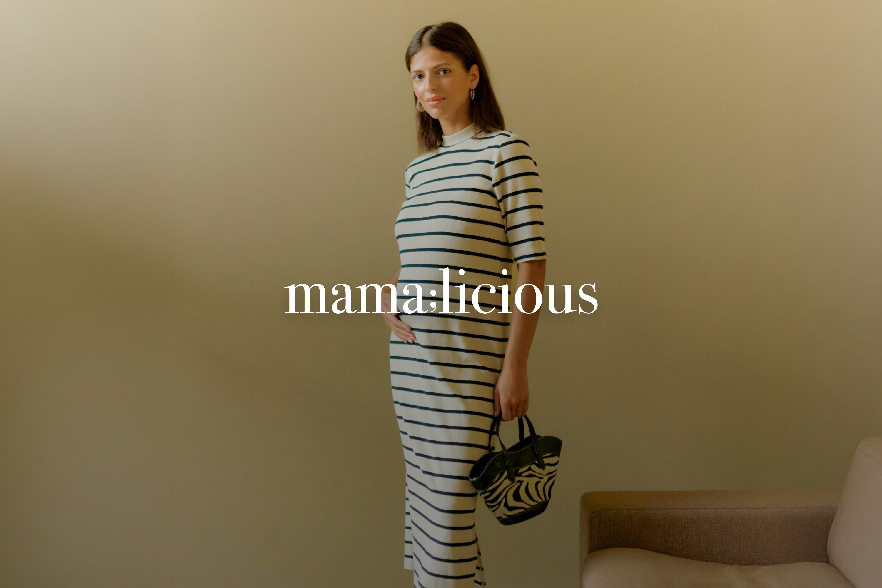 Femme enceinte portant une robe rayée et tenant un sac à main zébré.