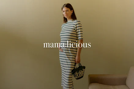 Femme enceinte portant une robe rayée et tenant un sac à main zébré.