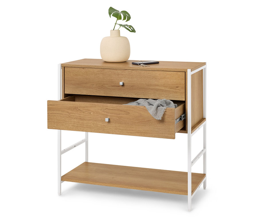 Commode à deux tiroirs, le supérieur fermé et l'inférieur légèrement ouvert, avec sur le dessus un vase avec une plante, un téléphone portable et une clé.