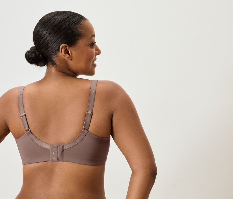 Vue arrière d'une femme aux cheveux relevés portant un soutien-gorge taupe.