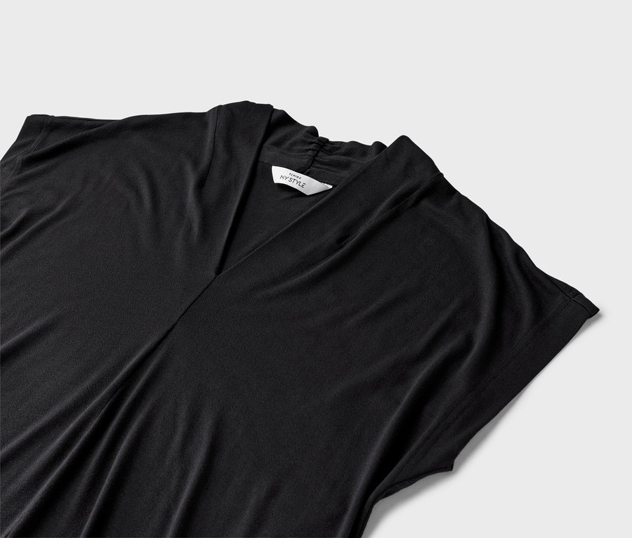 Gros plan d'une robe noire à col en V sur un fond neutre.