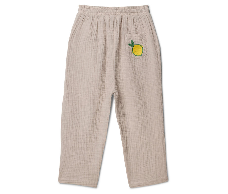 Pantalon beige en tissu avec taille élastique et poche plaquée avec un citron appliqué.
