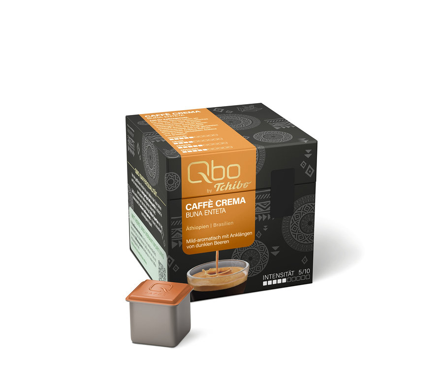 Emballage noir de capsules Qbo Caffè Crema BUNA ENTETA avec bande orange, une capsule et un bol avec un filet de café.