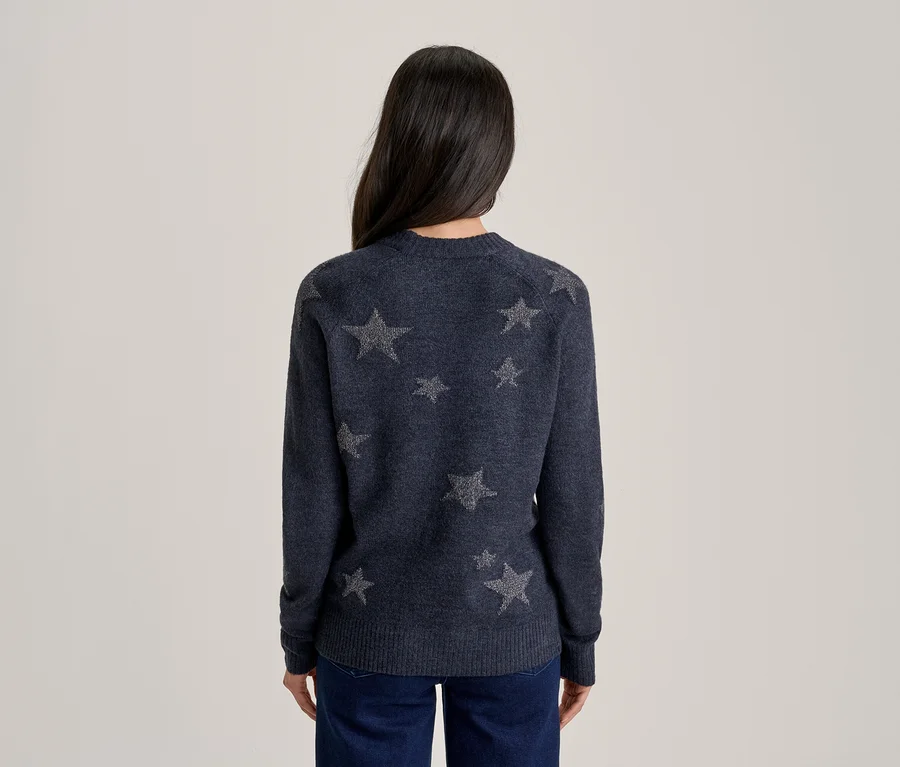 Personne vue de dos portant un pull bleu foncé à motifs d'étoiles grises et un jean bleu foncé.