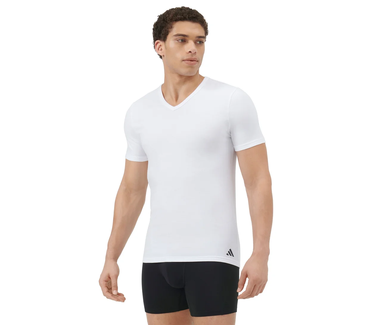 Homme portant un t-shirt blanc à col en V et un boxer noir, debout et regardant vers la droite sur un fond blanc.
