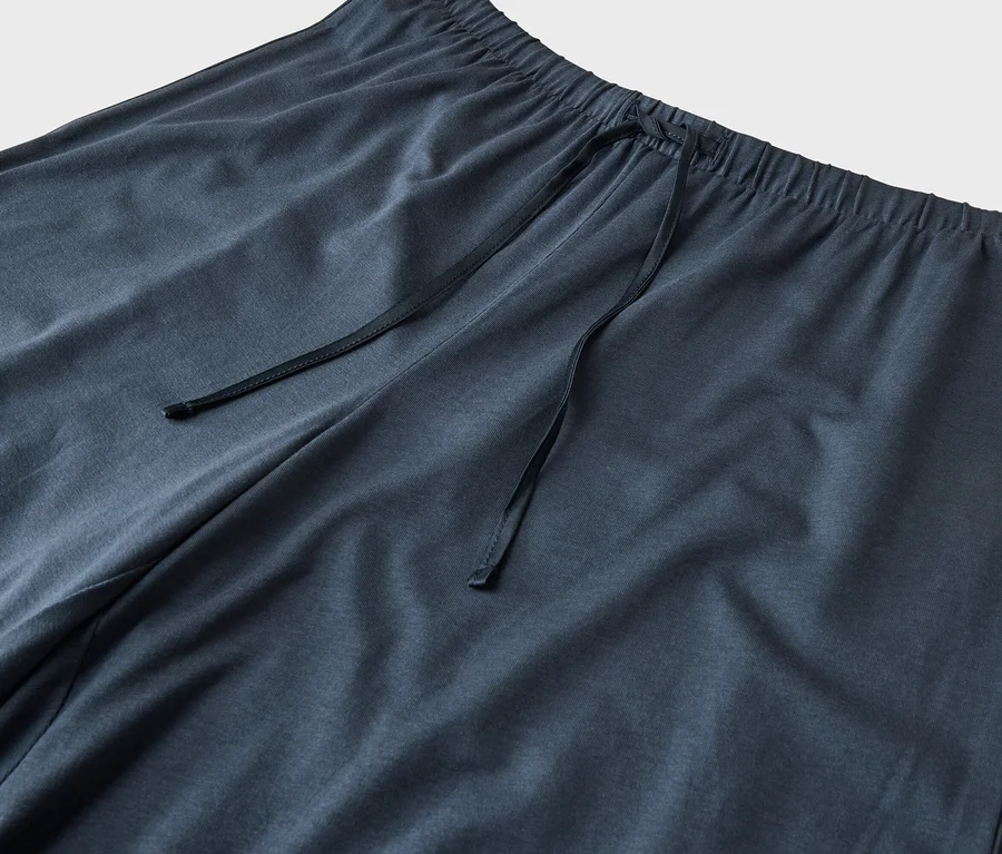Gros plan d'un pantalon de jogging bleu foncé avec une taille élastique et un cordon de serrage.