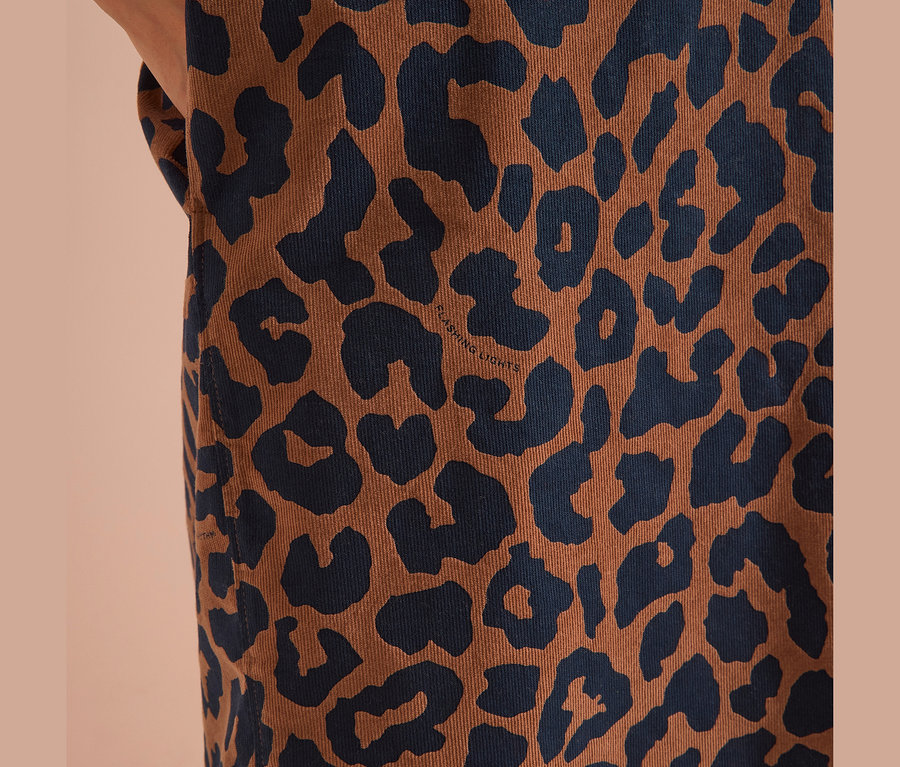 Gros plan d'une robe en velours côtelé CECIL à motif léopard marron avec des taches bleu foncé. Le texte « FLASHING LIGHTS » est visible.