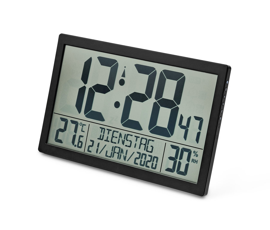 Une horloge radio-pilotée XXL noire affiche 12:28, 27,6 degrés Celsius et 30% d'humidité.