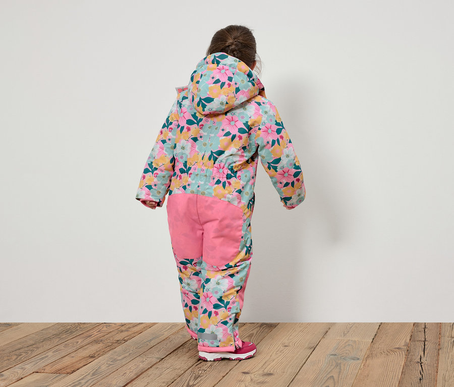 Vue de dos d'un enfant portant une combinaison à fleurs avec une capuche et un pantalon rose.