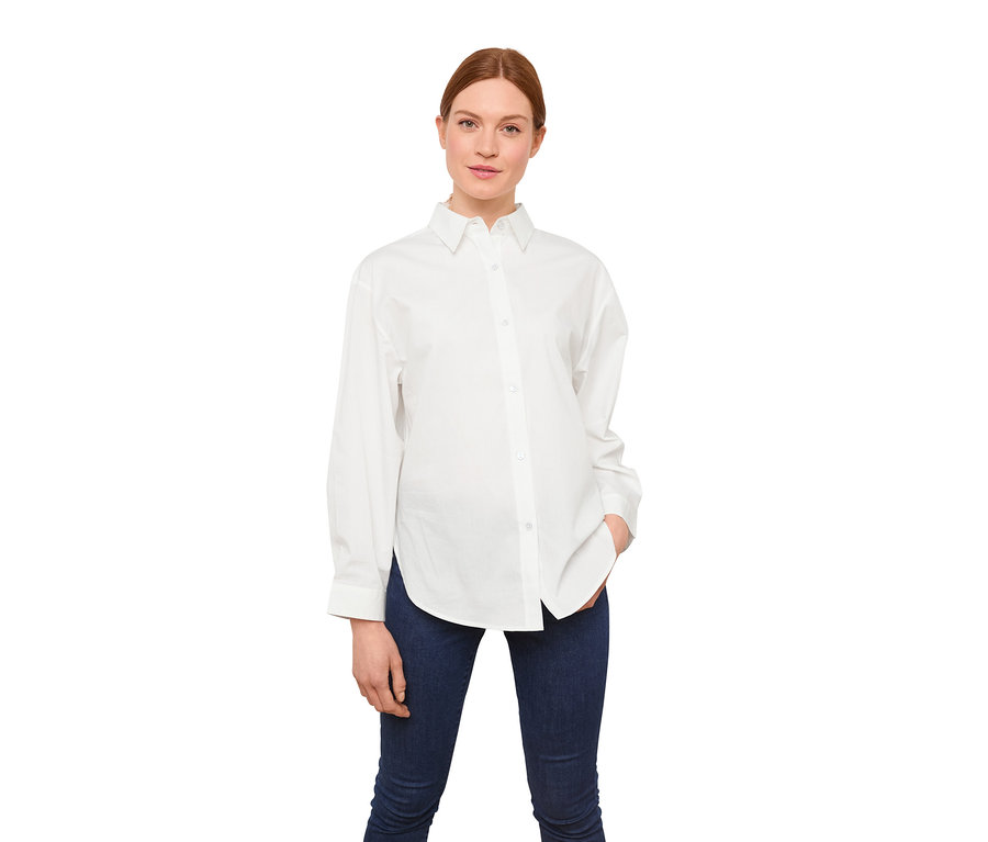 Femme posant en chemisier en popeline blanc.
