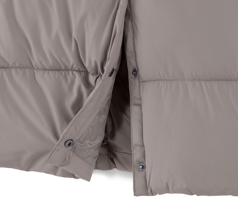 Gros plan sur un manteau matelassé à capuche taupe, partiellement déboutonné.