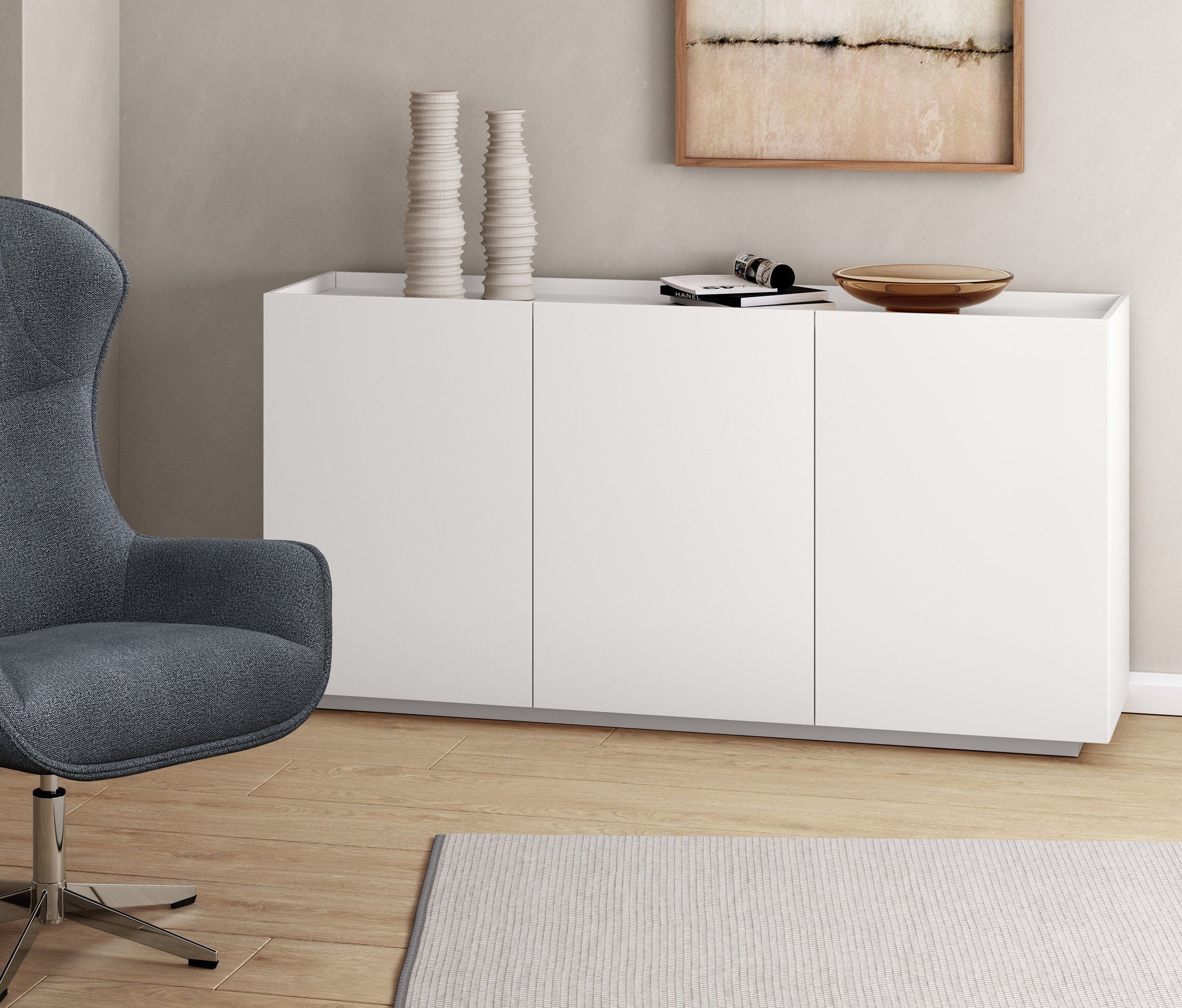 Fauteuil pivotant gris à côté d'un buffet blanc.