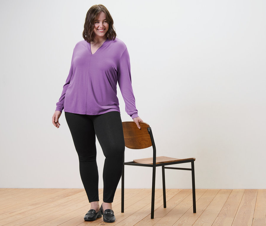 Femme posant en blouse à encolure en V et jegging.