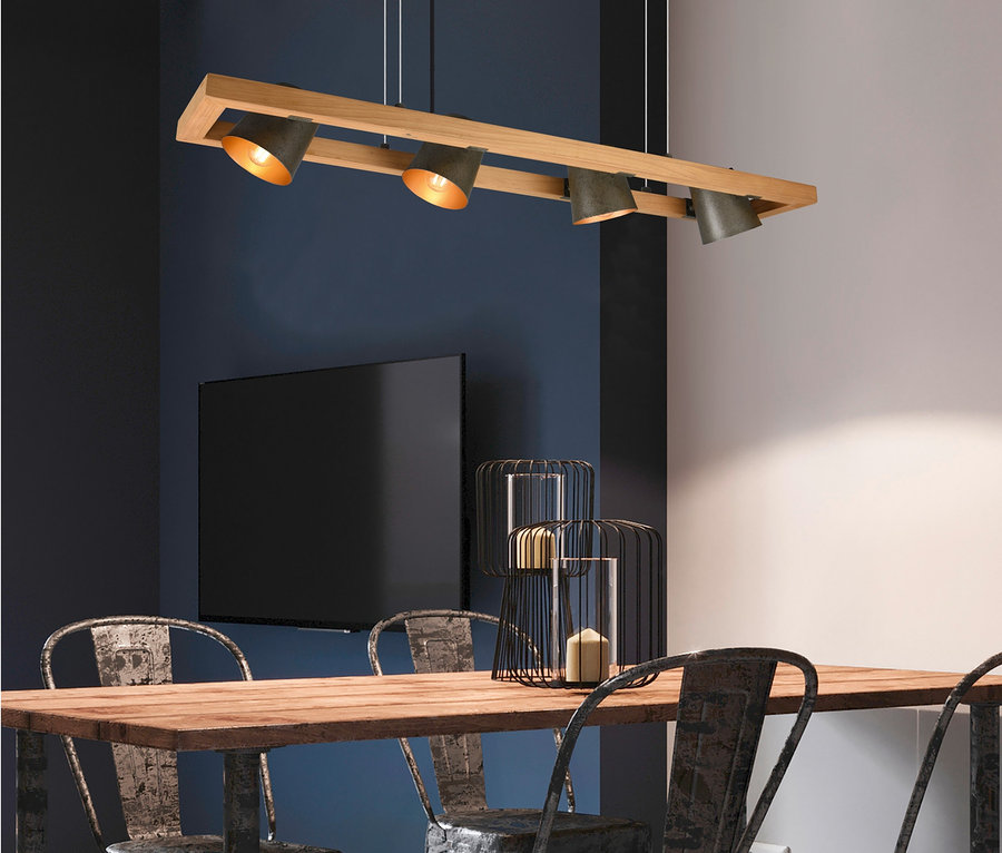 Table avec quatre chaises sous une suspension à quatre lampes Trio Bell.