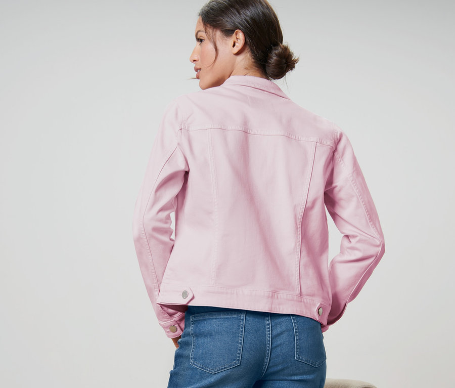 Femme vue de dos portant une jaquette en jeans rose pâle.
