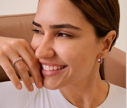 Gros plan sur le visage d'une femme portant des créoles et une bague en argent 925.