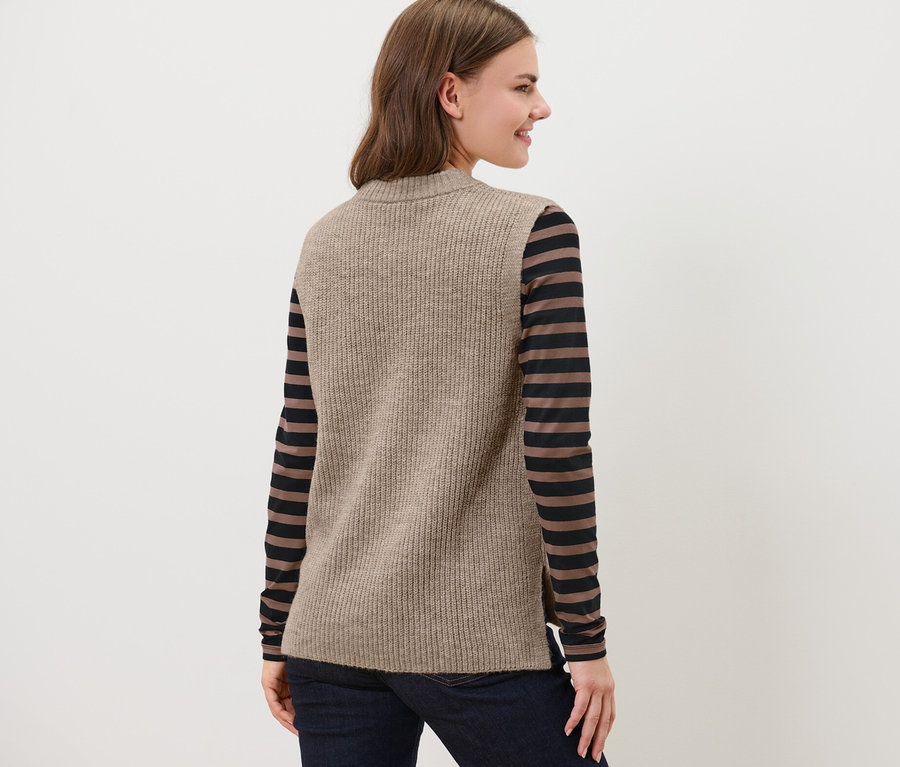 Femme portant un pull sans manches en maille beige chiné.