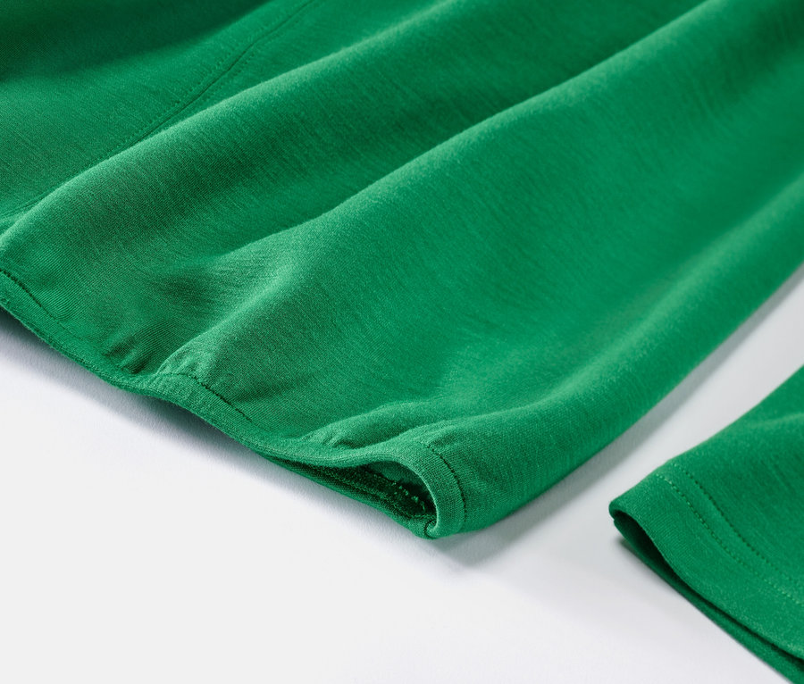 Gros plan sur une blouse verte en modal mélangé sur fond blanc.