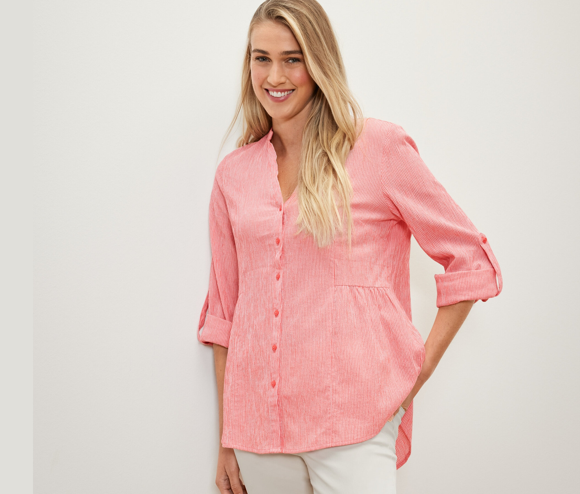 Femme posant en tunique longue rayée corail.