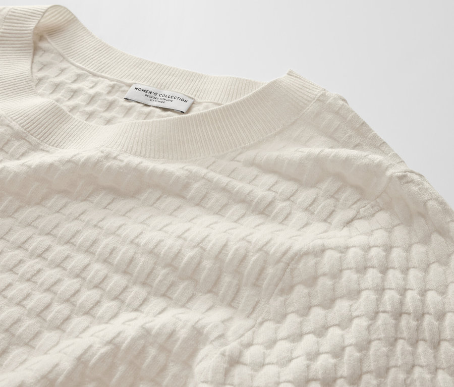Gros plan sur un pull-over en maille structurée.