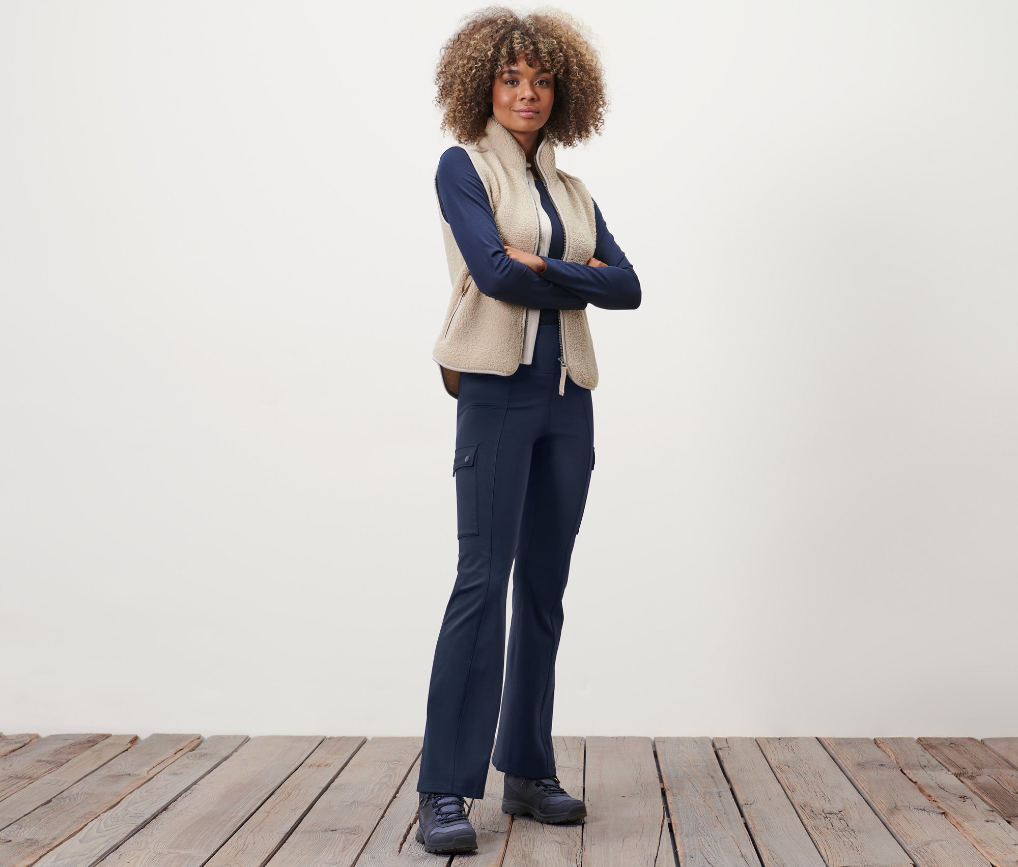 Femme posant en pantalon jazz thermique, pull et gilet.