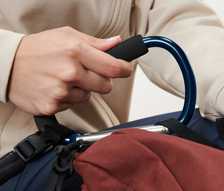 Une personne tient un mousqueton bleu XXL, 2 pièces, attaché à un sac à dos marron.