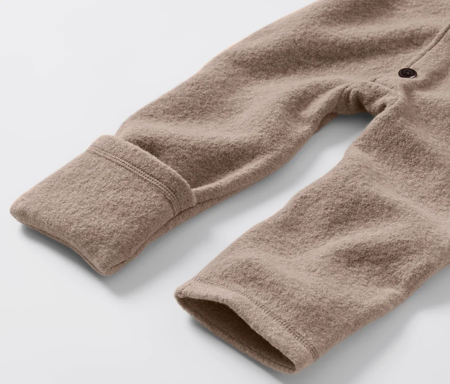 Gros plan sur une combinaison marron pour bébé en laine mérinos.